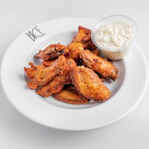 Ailes de poulet BBQ servies avec une sauce douce Signature, spécialité d’Italian cuisine