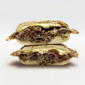 Sandwich Steak Pepperoni avec pain panino au sésame, cheddar, sauce Bombe, oignons caramélisés et pepperoni