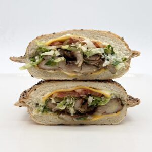 Poulet grillé en sandwich panino au sésame avec cheddar, mayo, laitue et tomate