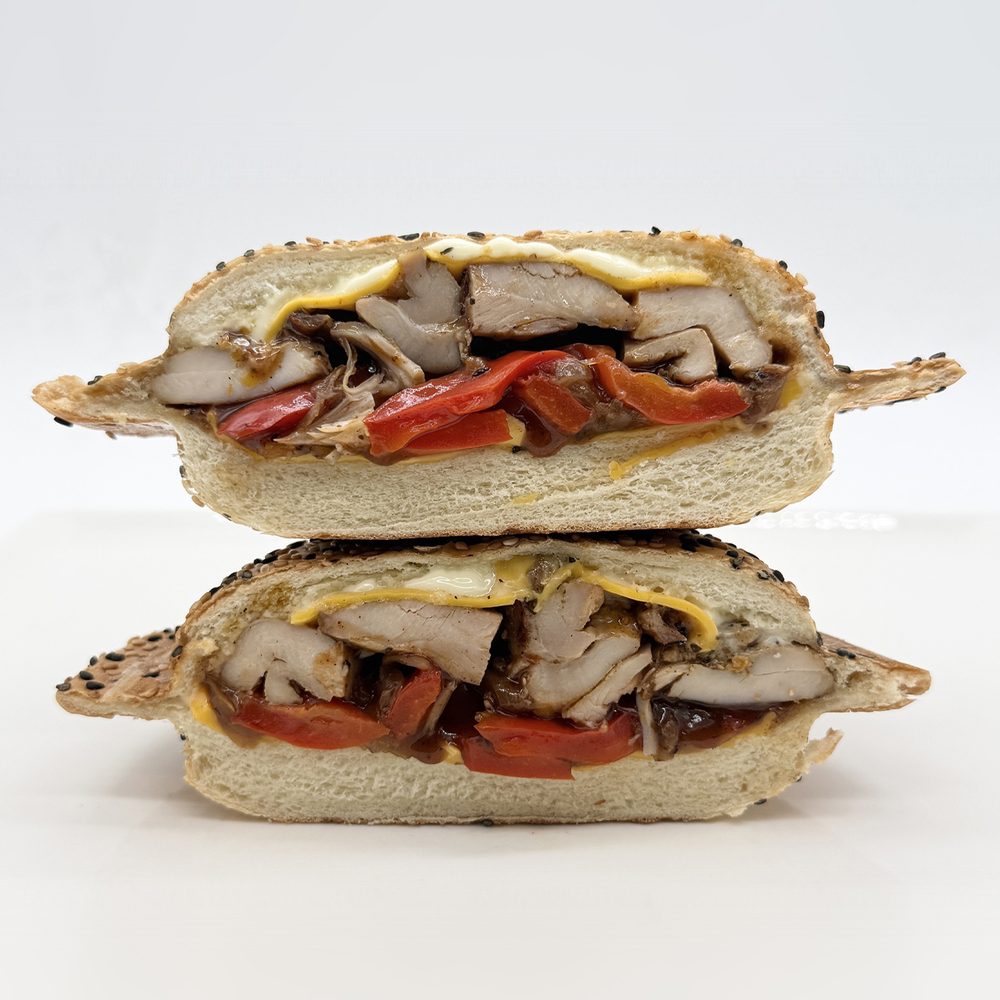 Poulet grillé BBQ en panino Panino au poulet grillé BBQ avec cheddar, mayo, oignons caramélisés et poivrons rôtis