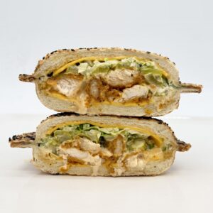 Poulet frit Bice dans un pain panino au sésame avec cheddar, sauce Gold maison, cornichons et laitue