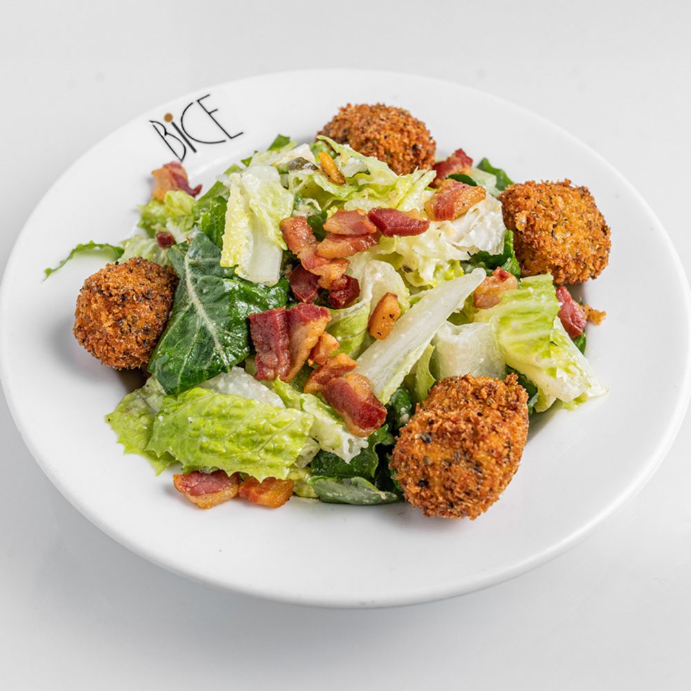 Salade César à la pancetta Salade César avec cœurs de romaine, pancetta dorée, croûtons, parmesan râpé et poivre noir